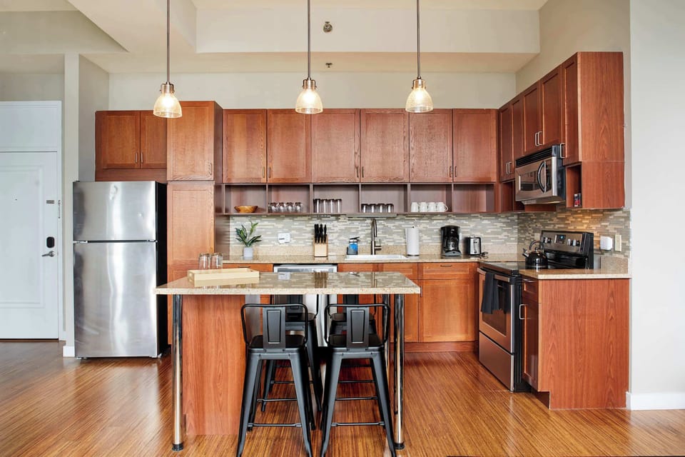 Kitchen with large island with 4 counter stools