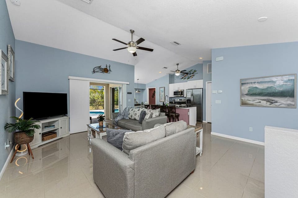 Spacious open concept living area with vaulted ceilings, comfortable seating, a sofa sleeper, and a smart Roku TV, plus books and games available for guests to enjoy during their stay.
