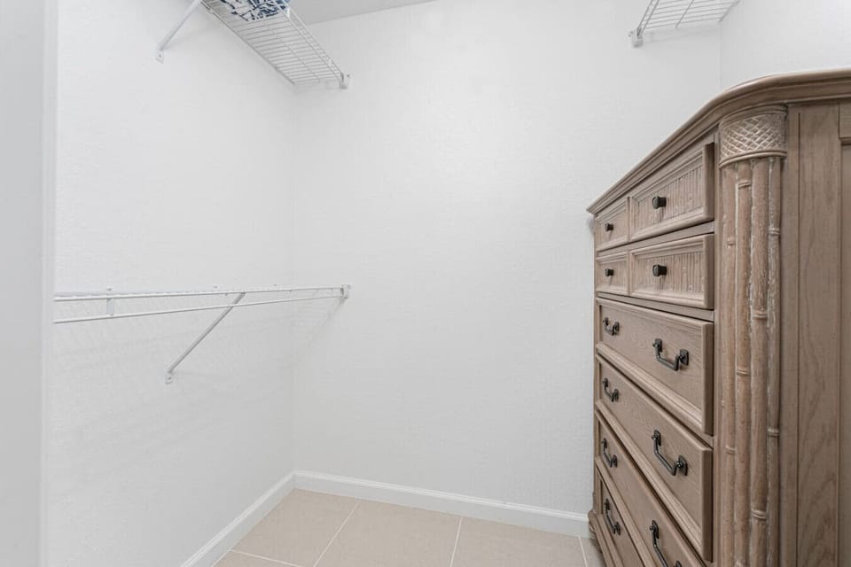 Walk-in closet off the primary bedroom with hangers, a dresser for additional storage, and extra blankets and pillows available for guest use.