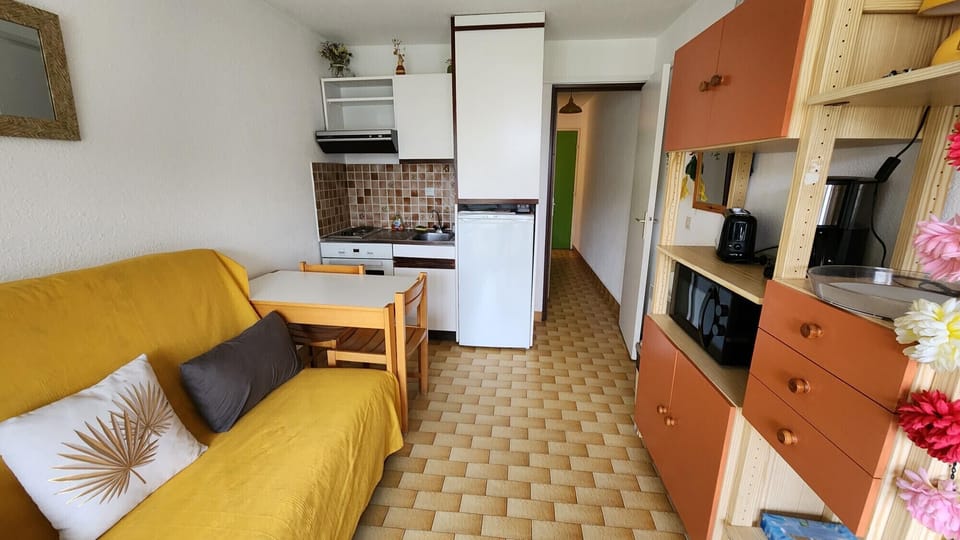 Living area with sofa bed for two, open to the dining area and fully equipped kitchen (oven, microwave, toaster, refrigerator, etc.)