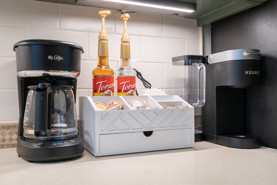 Coffee Bar with an assortment of k-pods, creamer, sugar, syrups, and tea