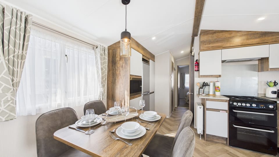 Open-plan kitchen & dining area with dining table, oven, microwave and fridge-freezer.