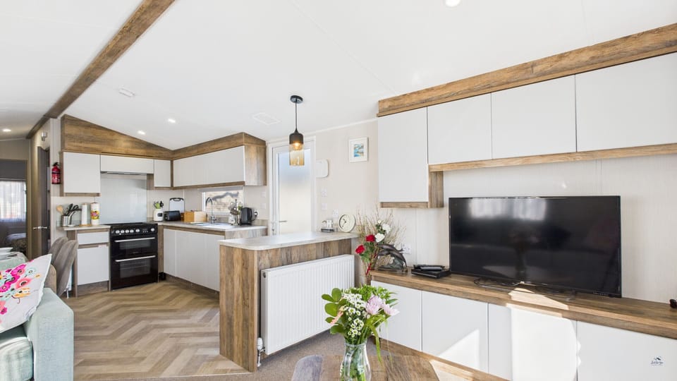 Bright living area with TV and breakfast bar.