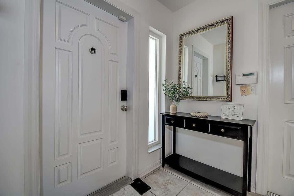 This beautifully designed entryway welcomes you with elegance, featuring a chic console table, a statement mirror, and the perfect touch of greenery #StylishEntryway 