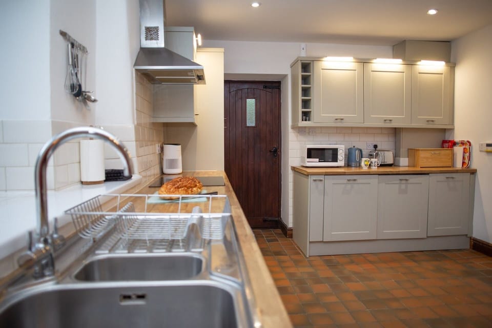 Modern kitchen with sink and drainer in foreground and grey cabinets in background