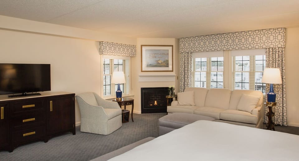 Spacious and inviting suite with a cozy seating area, warm fireplace, and stylish decor for a relaxing stay.