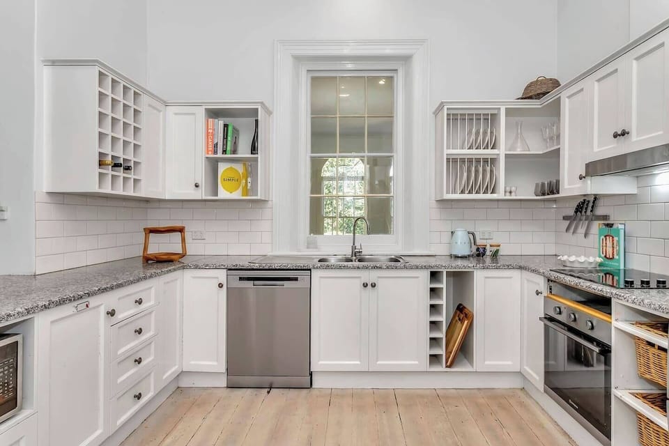Experience the crisp charm of this country-style kitchen, ideal for daily meal prep or hosting guests at the expansive benchtops, complemented by a sash window above the sink.