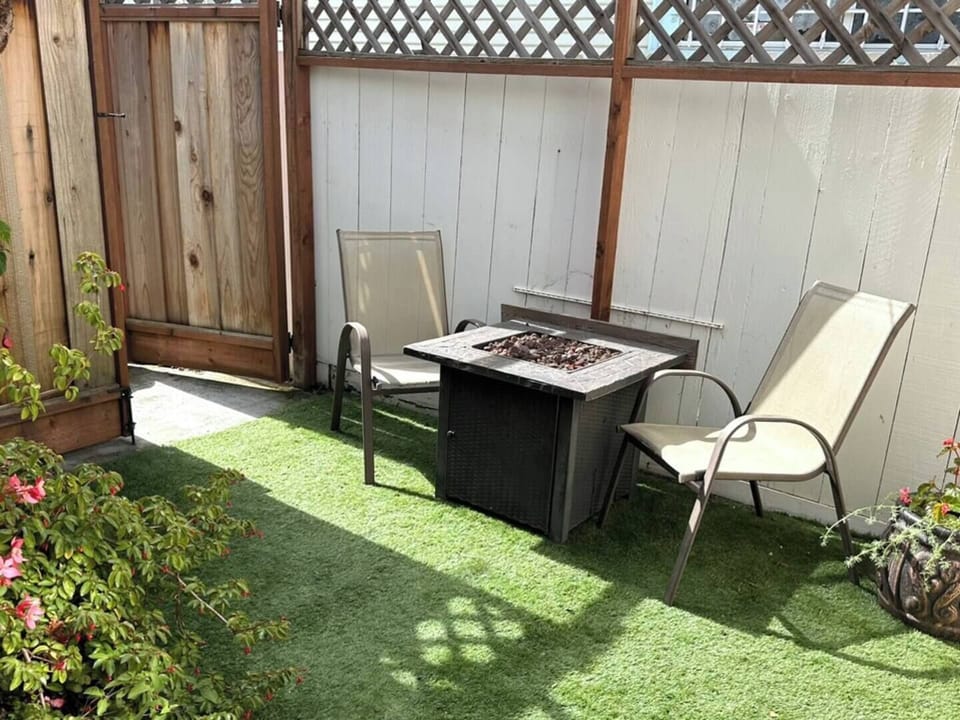 private patio corner with comfortable lounge chairs and a fire table