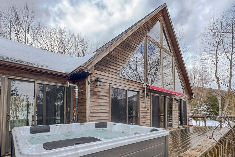 Enjoy the best of indoor and outdoor living with this stunning A-frame cabin and a relaxing hot tub on the deck.