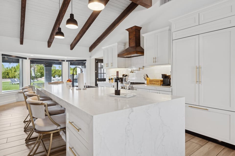 Chef’s kitchen with marble island, custom cabinets, and backyard views