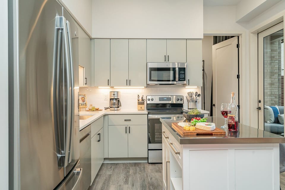 Unit 1: Fully equipped kitchen featuring  stainless steel appliances with a kitchen island offering bar seating for 2 guests.