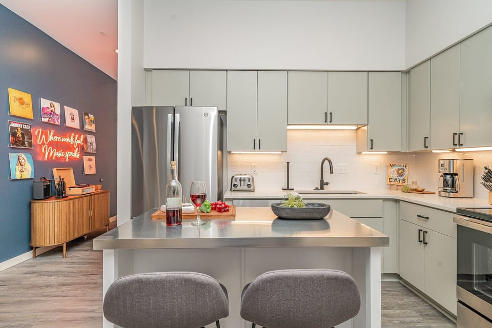 Unit 1: Fully equipped kitchen featuring  stainless steel appliances with a kitchen island offering bar seating for 2 guests.