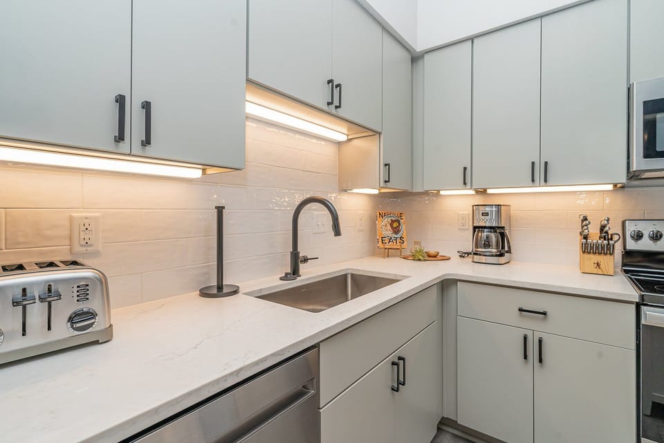 Unit 1: Fully equipped kitchen featuring  stainless steel appliances with a kitchen island offering bar seating for 2 guests.