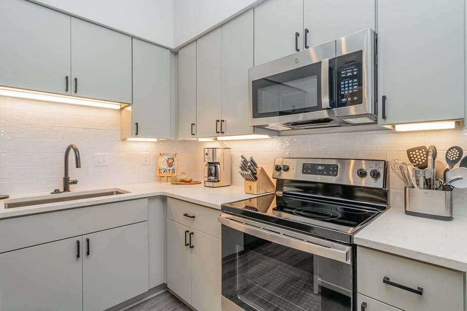 Unit 1: Fully equipped kitchen featuring  stainless steel appliances with a kitchen island offering bar seating for 2 guests.