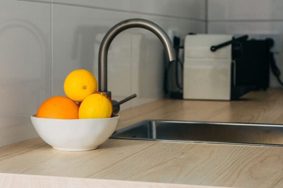 Frische Akzente in der Küche – ein Hauch von Sonne für dein Frühstück, begleitet von aromatischem Kaffee aus der stilvollen Maschine im Hintergrund.