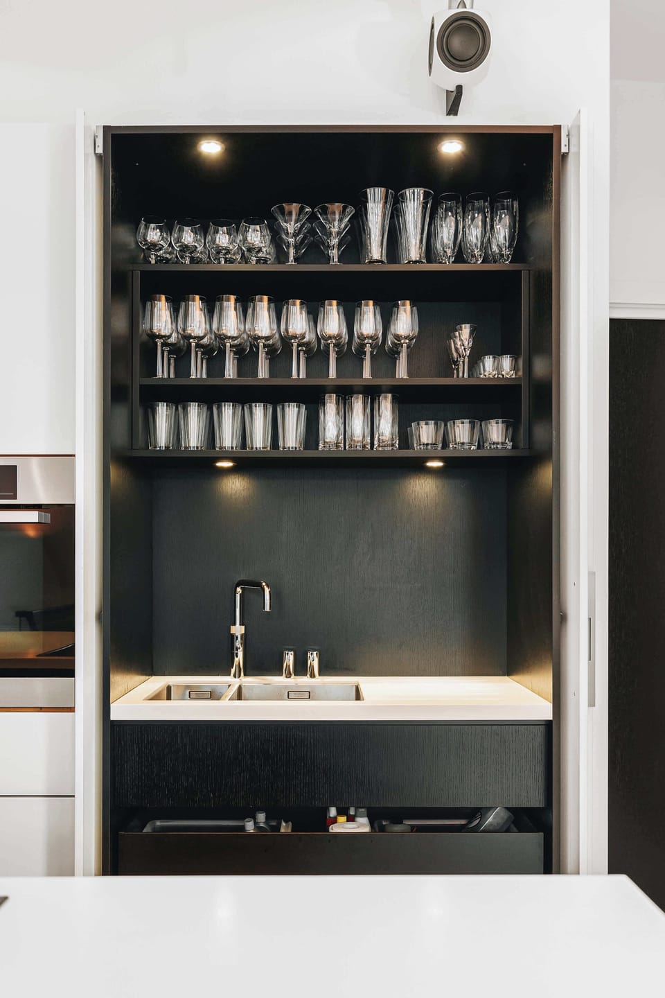 The kitchen's built-in bar, showcasing a curated collection of glassware.