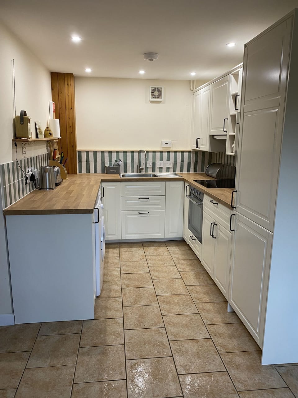 Modern kitchen with a large fridge/freezer, induction hob and cooker, dishwasher and washing machine.