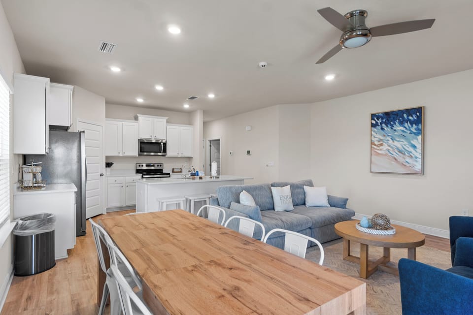 Relax in your spacious open-concept living area where the full kitchen flows seamlessly into comfortable seating perfect for gathering.