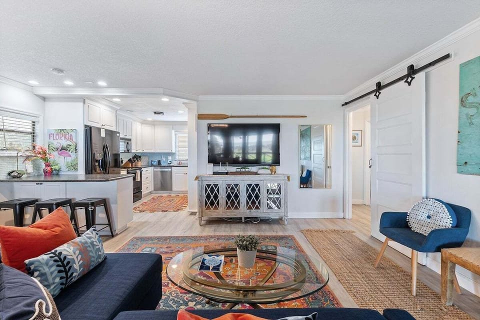 Step into the heart of this stunning vacation retreat, where an open floor concept seamlessly connects the living room, dining area, and kitchen, creating a bright and airy space perfect for gathering.