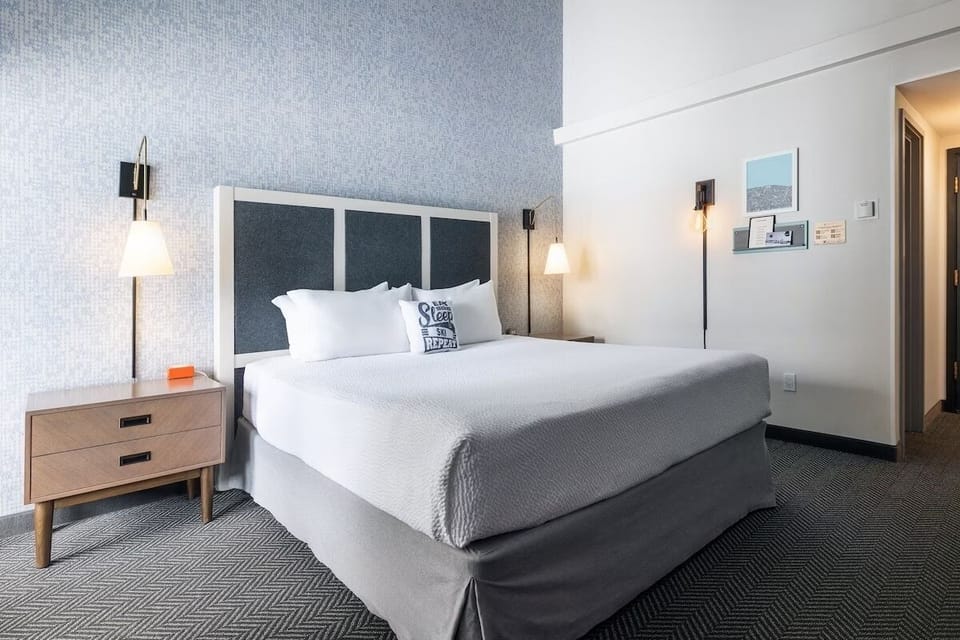 Unwind in a crisp king bed under warm bedside lighting.