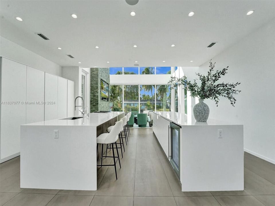 Refined culinary space showcasing contemporary design excellence with luxury double island configuration and abundant natural light