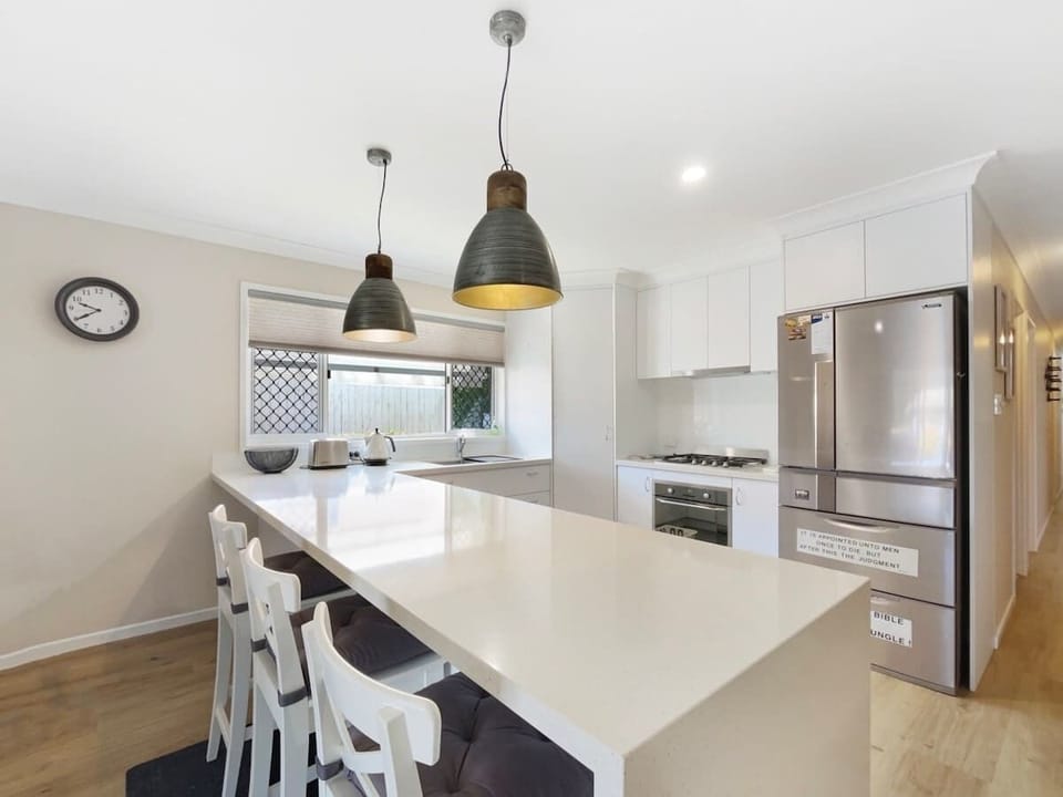 Bright and functional, the well-equipped kitchen includes a gas cooktop, dishwasher, and a breakfast bar perfect for casual dining.