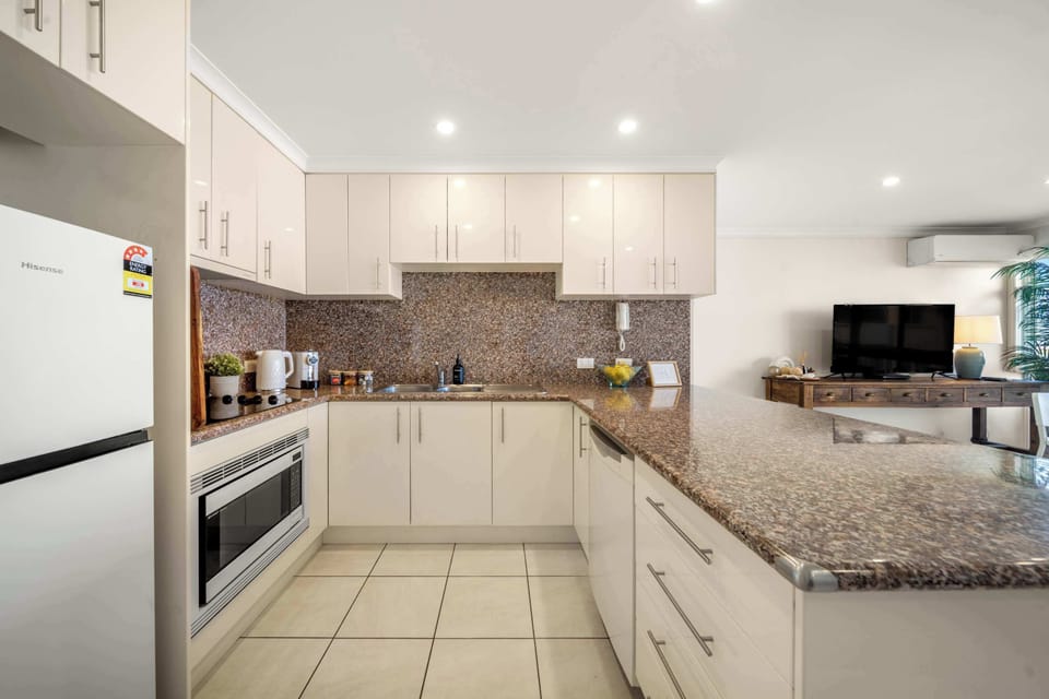 Practical holiday kitchen with fridge freezer oven cooktop dishwasher toaster and kettle