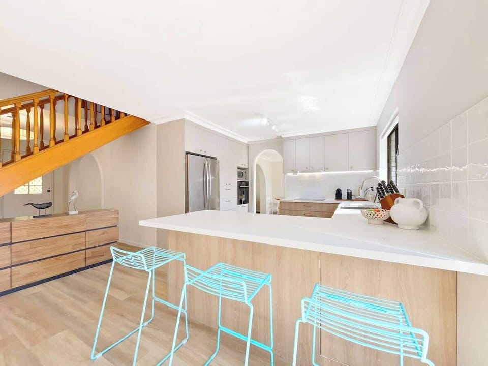 A sleek breakfast bar provides seating for three.