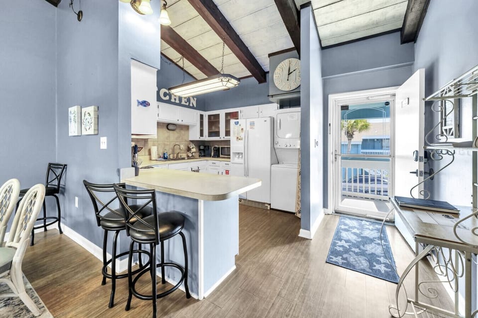 Bright, fully equipped kitchen with a breakfast bar and open layout, perfect for cooking, gathering, and starting your day with coffee.