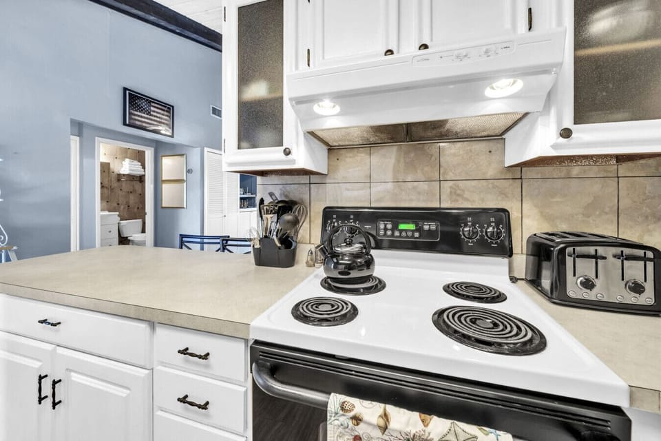 Fully equipped kitchen with stove and cooking essentials.