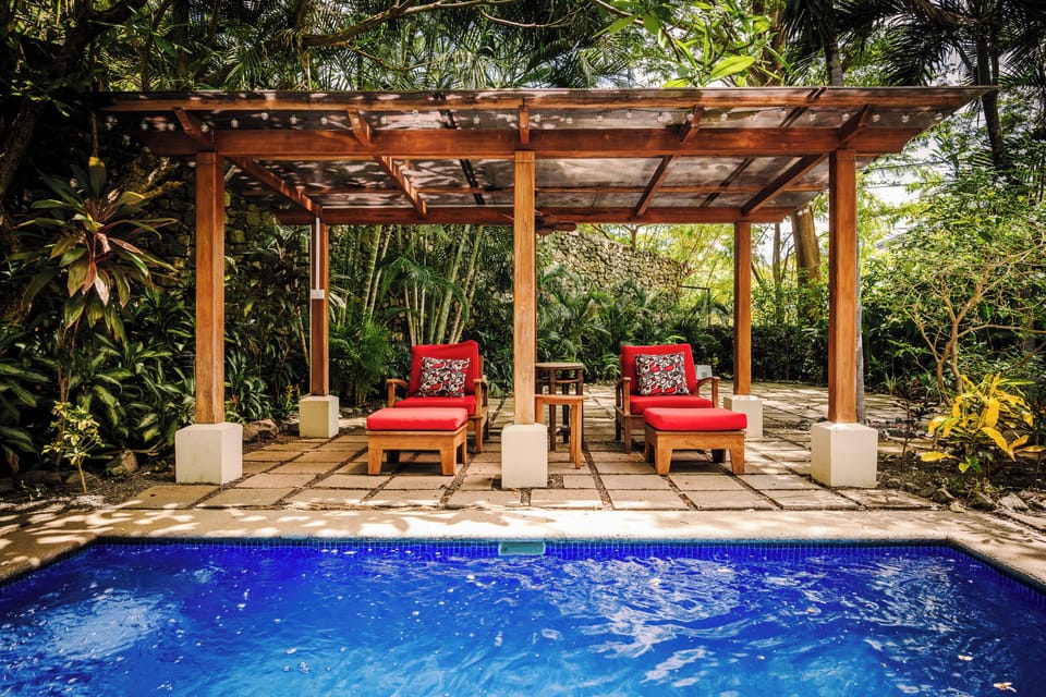 Elegant view from the house with cozy bungalow beyond the pool at this exclusive villas Tamarindo. Comfortable seats surrounded by lush garden and deep nature. Perfect for relaxation, birdwatching, and enjoying Costa Rica's tropical paradise.