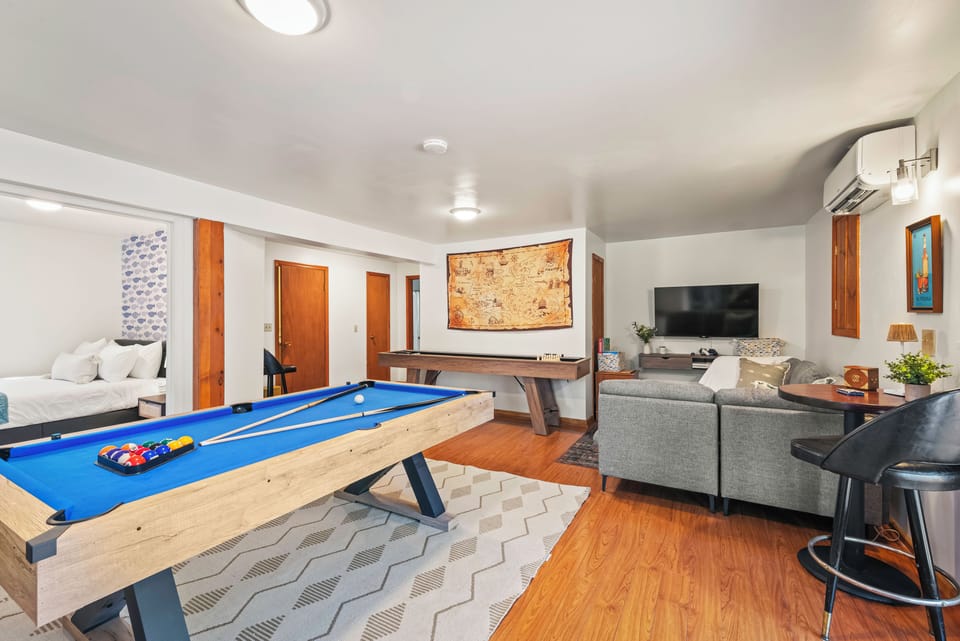 Step into the ultimate game room, featuring a pool table, shuffleboard, and a game console for endless entertainment!