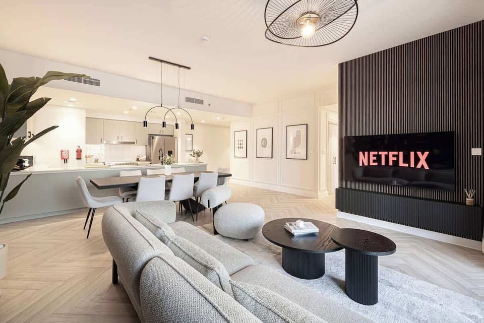 Cozy living room with a 65″ smart TV and Netflix. The open layout connects smoothly to the kitchen, creating a comfortable space to relax after a day in the city. 