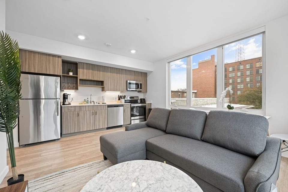 Embrace modern living in a seamlessly connected space, where the living room flows into a dining area and an open-layout kitchen.