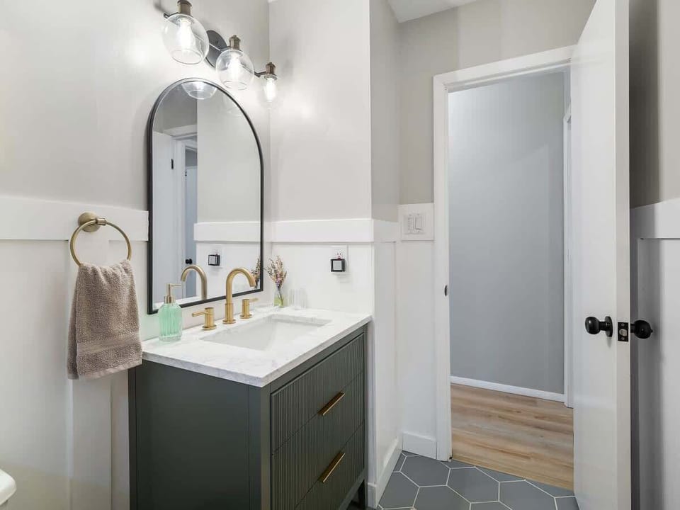 Clean bathroom w/ vanity, sink & shower-tub combo for everyday ease