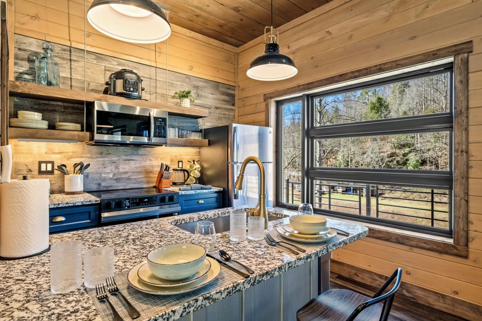Start your mornings in style with a gourmet kitchen that features granite countertops, open shelving, and modern stainless steel appliances.