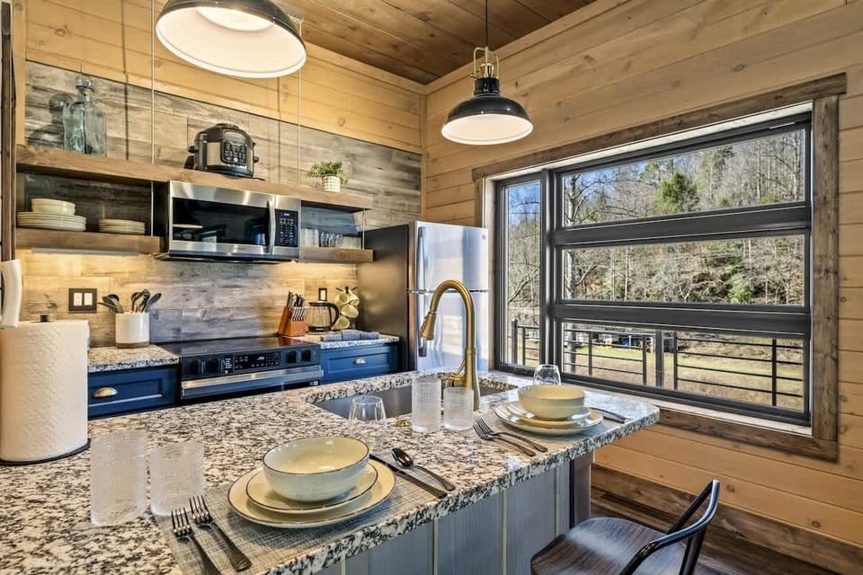 Start your mornings in style with a gourmet kitchen that features granite countertops, open shelving, and modern stainless steel appliances.