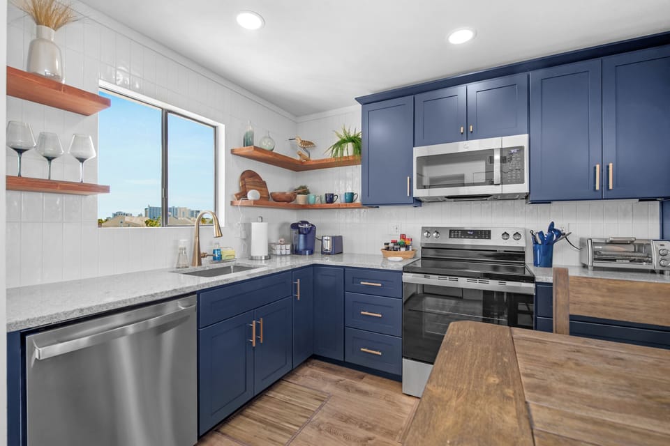 Shiny backsplash and shelves complete the modern beachy style.