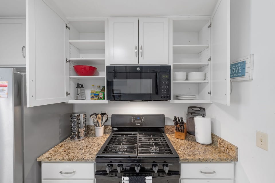 Open shelving stocked with dishes, cookware, and essentials for your stay.