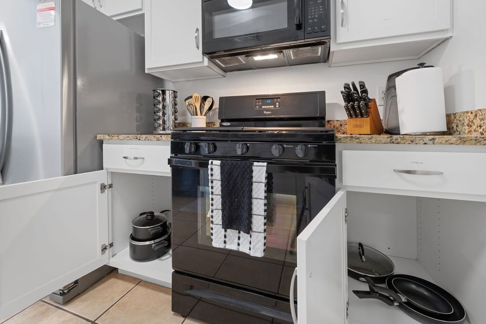 Well-organized kitchen with cookware and tools at hand.