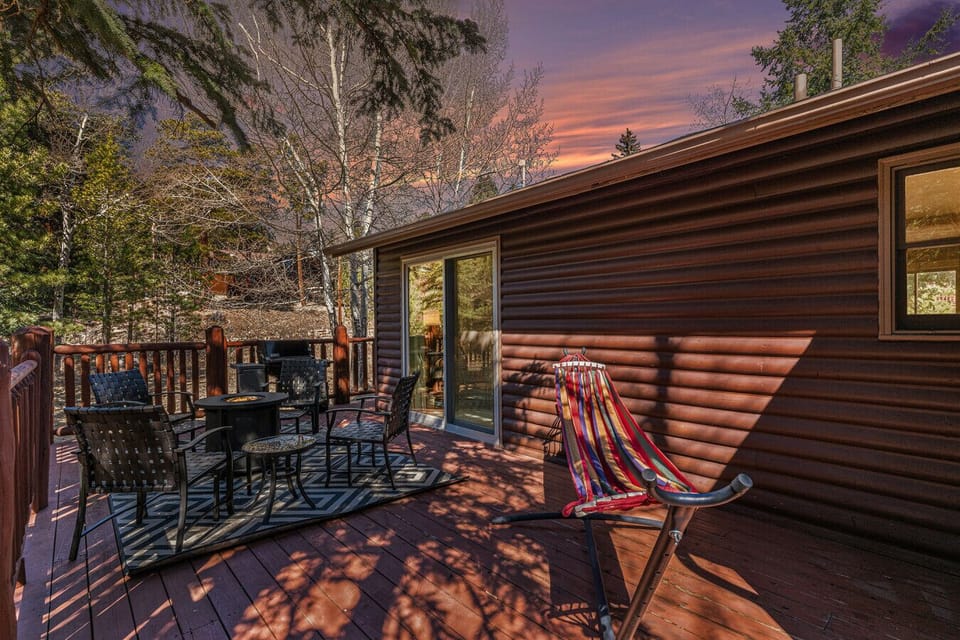 Warmth from the fire and the fading light of the sunset paint the deck with a magical glow as you relax in the hammock.