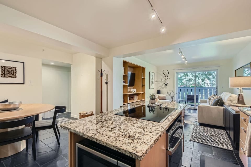 From the kitchen, see how thoughtfully designed this one-bedroom flows, island with microwave and stovetop opens to the dining table, which connects seamlessly to the living room. Every square foot maximized for comfort and functionality