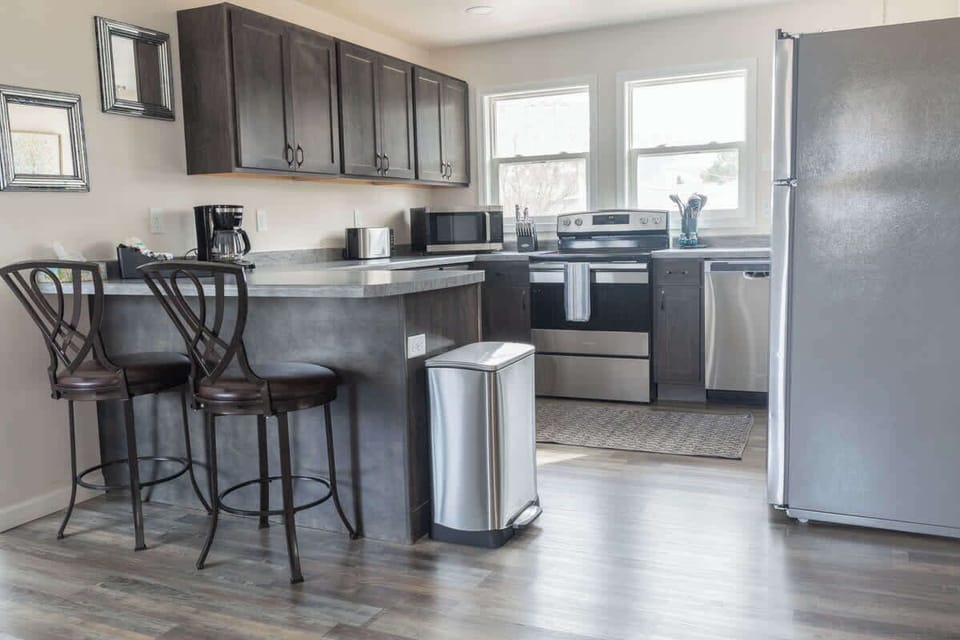 This sleek, open-concept kitchen features stainless steel appliances and a convenient breakfast bar, perfect for casual dining or entertaining. The open layout makes it easy to interact with family and friends while cooking.