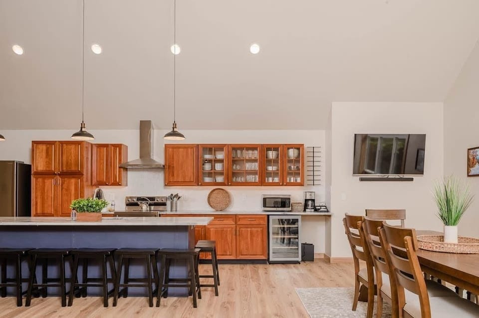 Full cooking kitchen with seating for 8 at the island. Features wine refrigerator, microwave, coffee station, tea kettle, and a smart tv. Dining room table seats 8. Kitchen includes full set of pots & pans, dishes, silverware, and wine glasses.