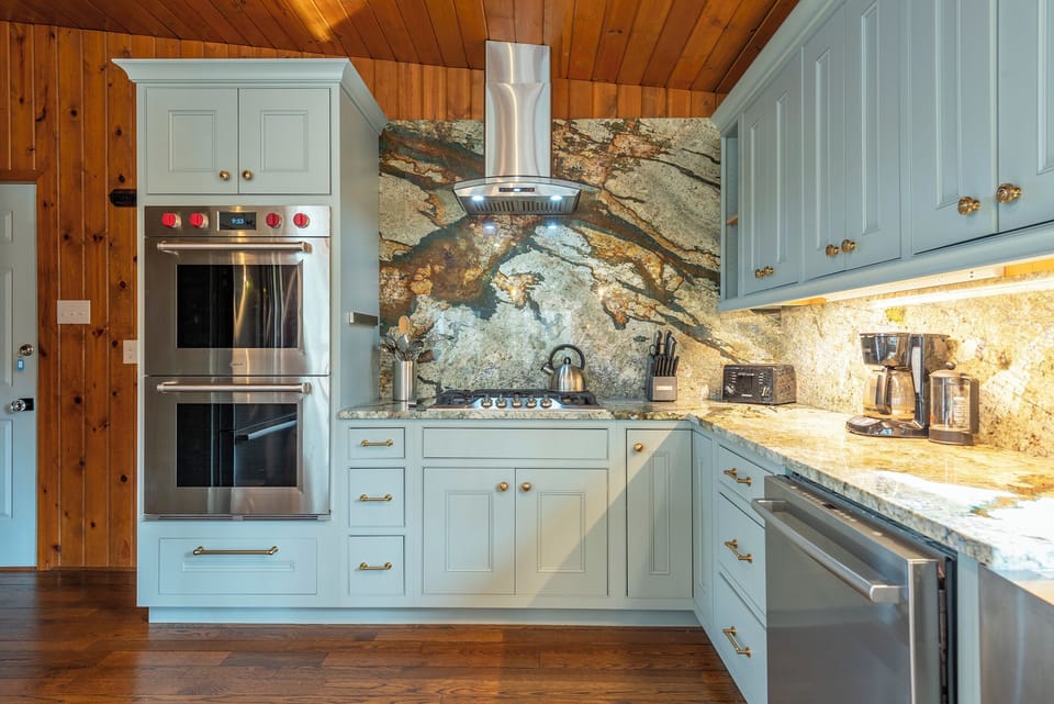 Kitchen with gas range, double oven, dishwasher, drip-style coffee maker, and breakfast bar seating for 3