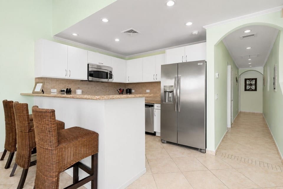 Fully equipped kitchen featuring modern appliances, cookware, essentials, and ample space for meal preparation.
