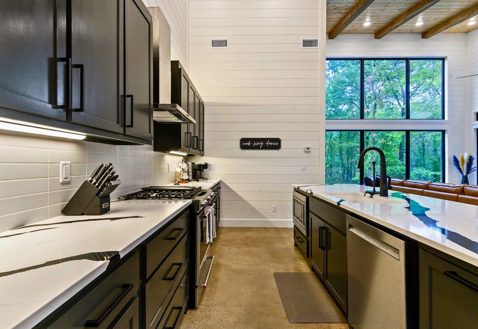 A full view of the kitchen reveals top-notch appliances, deep counters, and easy access to the dining area and beyond.