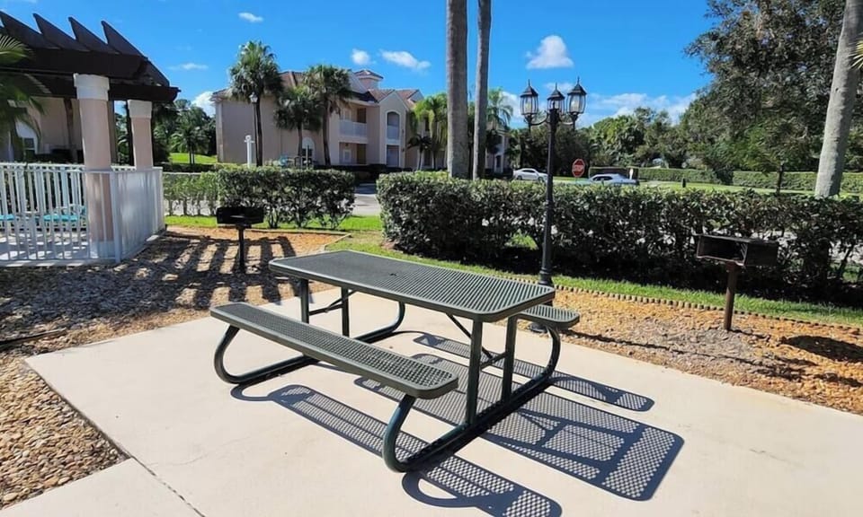 Outdoor community picnic area with shaded seating and landscaped surroundings near the pool.