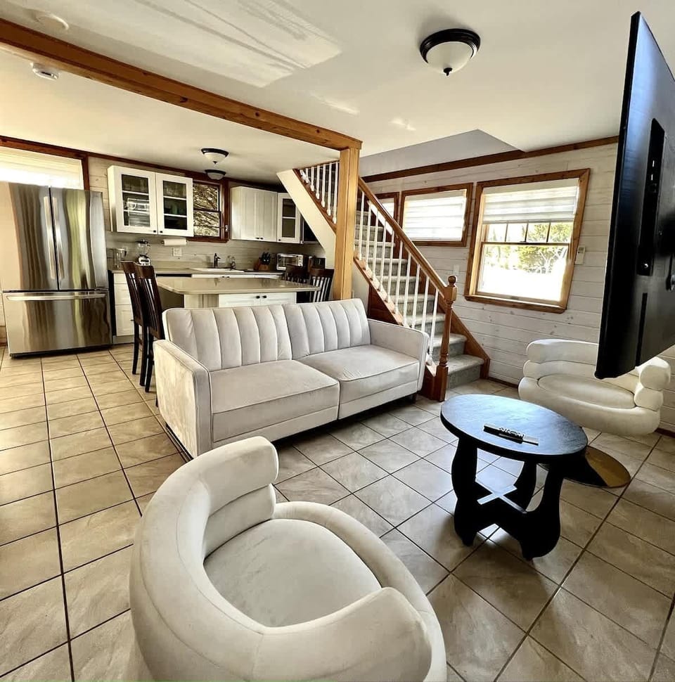 Kitchen, dining table and living room featuring a comfortable sofa bed and Tv. 