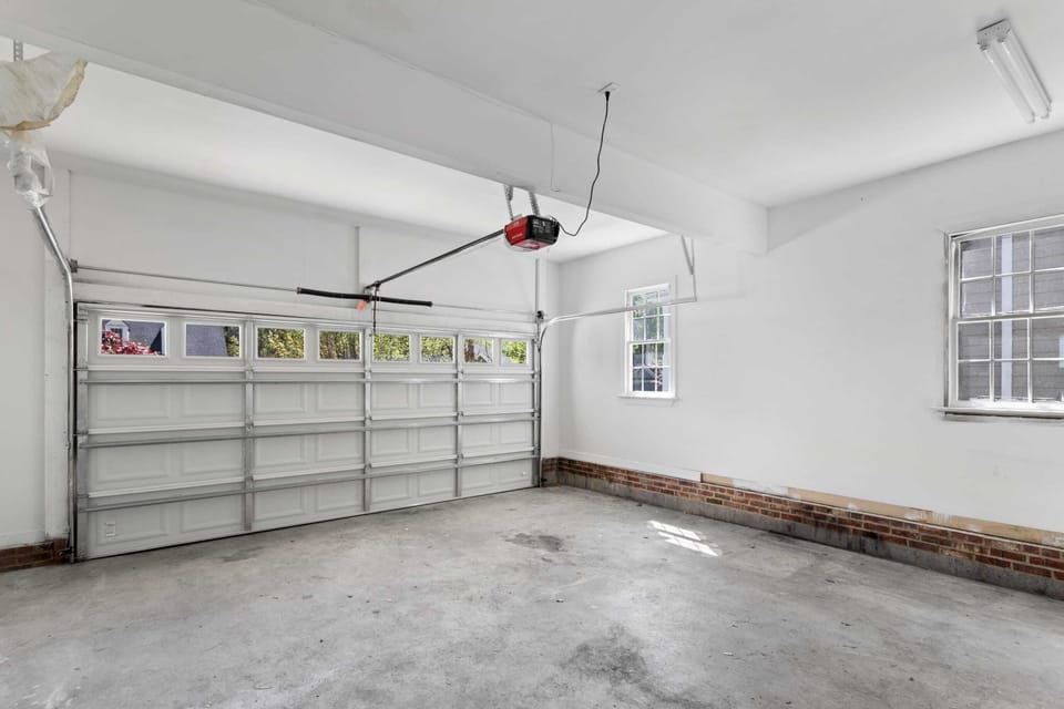 This clean and spacious two car garage offers a secure place for your vehicle. It is equipped with a modern EV charging station and bright windows, providing a well lit area for parking or organizing your travel gear during your stay.